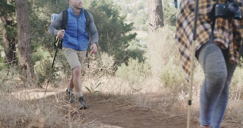 Happy Couple Hiking Together in Sunlit Forest Setting