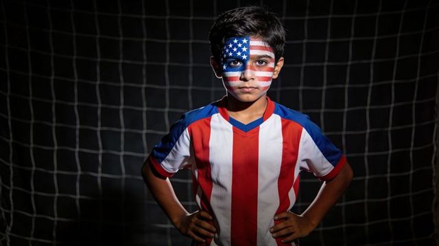 Youth soccer player with usa flag face paint posing in goal with dramatic lighting