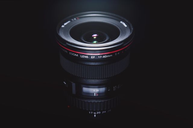 A high-quality professional camera lens is showcased against a dark background, with its detailed components and lens elements clearly visible. This can be used for articles on photography, advertisements for camera equipment, or web content discussing advanced photography techniques.