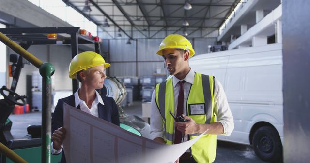 Industrial Workers Collaborating with Blueprints in Factory Warehouse - Download Free Stock Images Pikwizard.com