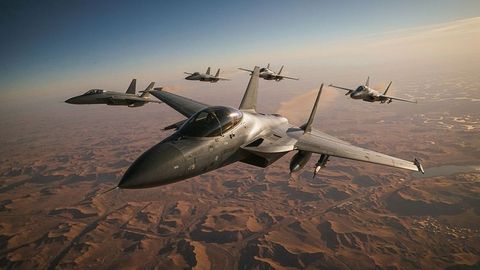 Military fighter jets flying in formation over airstrikes desert terrain