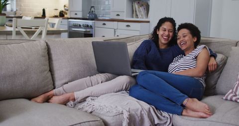 Smiling Couple Relaxing on Sofa with Laptop