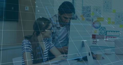 Young Professionals Collaborating at Desktop with Digital Grid Overlay for Design Planning