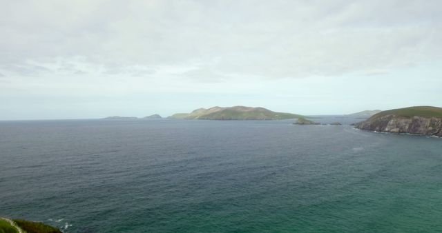 A serene seascape showcases a cluster of islands off a rugged coastline - Download Free Stock Photos Pikwizard.com