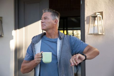 Man on Contemporary Porch Holding Coffee Mug Wearing Smartwatch