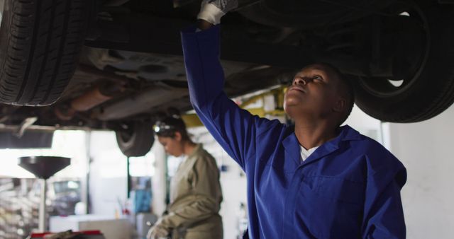 Mechanics Working Underneath Car in Auto Shop - Download Free Stock Images Pikwizard.com