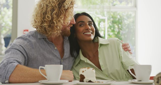 Happy diverse couple with coffee embracing and talking in cafe - Download Free Stock Photos Pikwizard.com