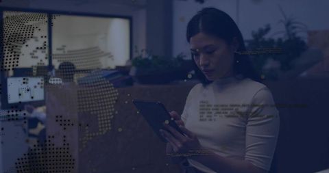 Chinese woman holding tablet focusing on digital data overlay in coworking space at night