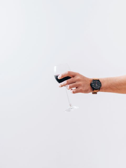 Hand Holding Wineglass of Red Wine Against White Background - Download Free Stock Images Pikwizard.com