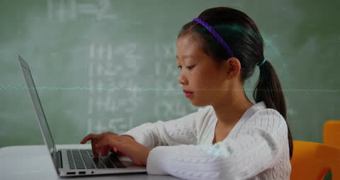 Asian Girl Typing on Laptop in Classroom with Digital Graphics