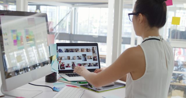 Asian Woman Innovatively Working at Modern Dual-Screen Desk - Download Free Stock Images Pikwizard.com