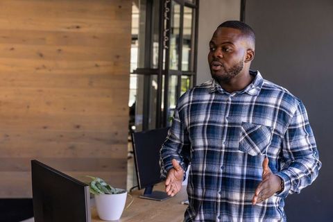 Professional Man in Plaid Shirt Discussing at Office Desk