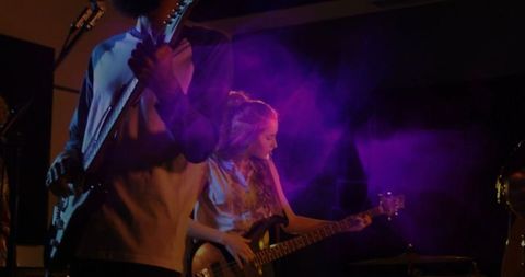 Energetic Live Performance of Rock Band with Blue-Purple Lighting Effects