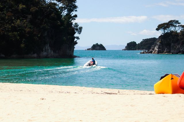 Person engaging in jet skiing on pristine turquoise waters near lush tropical islands. Motorized water sport perfect for summer travel themes, beach activities, vacation promotions, and tropical holiday concepts.