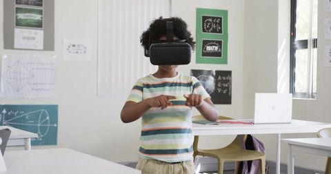 African American Child Exploring Virtual Reality in Classroom Wearing Headset and Pointing