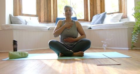 Focused Senior Woman Practicing Yoga Meditation Indoors