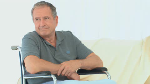 Senior Man in Wheelchair Contemplating at Home