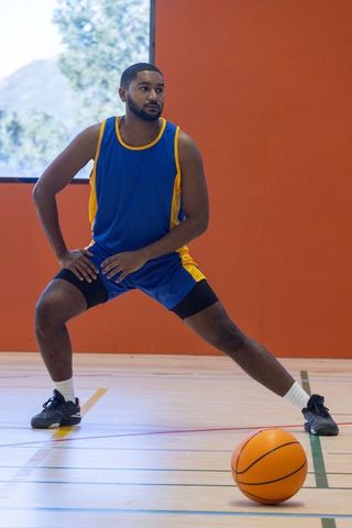 Athlete stretching on basketball court ready for game practice
