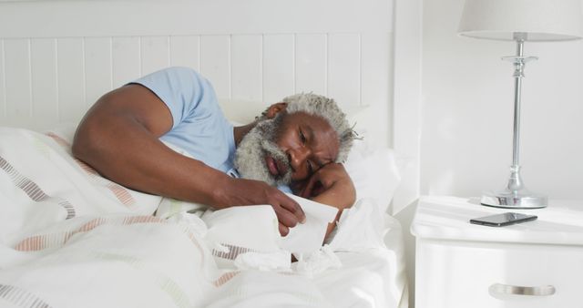 Sick african american man sleeping and lying in bed. Senior lifestyle, health domestic life, unaltered.