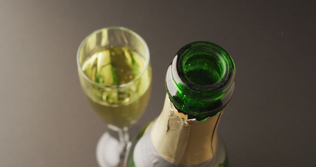 Image of champagne in glass and bottle on grey background. alcohol, beverage, drinks, party and celebration concept.