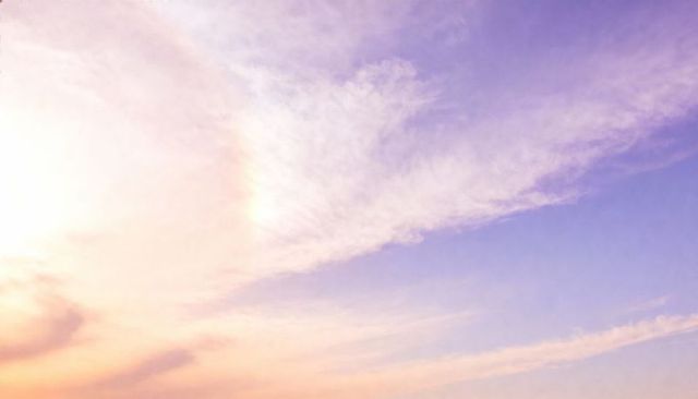 Expansive pastel sunrise cirrus cloudscape with peach to lavender sky gradient
