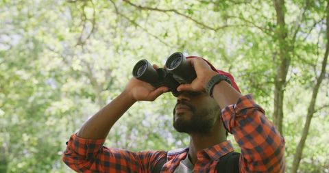 Young Hiker Using Binoculars for Wildlife Viewing