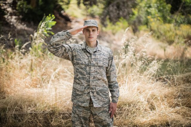 Portrait of military soldier giving salute in boot camp