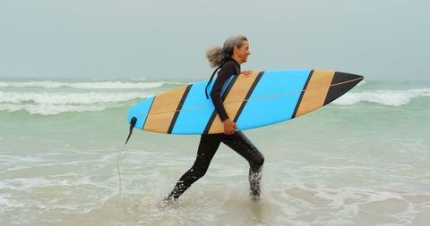 Senior African American Woman Excited to Surf in Ocean - Download Free Stock Images Pikwizard.com