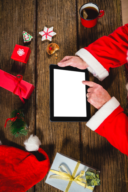 Santa Claus Hands Using Transparent Tablet at Festive Wooden Table - Download Free Stock Videos Pikwizard.com