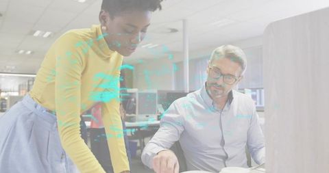 Colleagues collaborating over documents with futuristic holographic data overlay in office