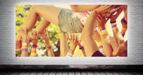 Festival Crowd Surfing Celebration Against Brick Background Display