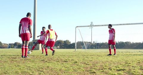 Male Soccer Players Practicing Passing in Park as Team