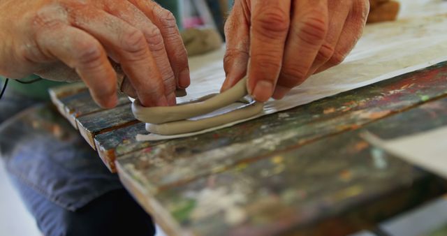 Adult hands crafting pottery ring on wooden table - Download Free Stock Images Pikwizard.com