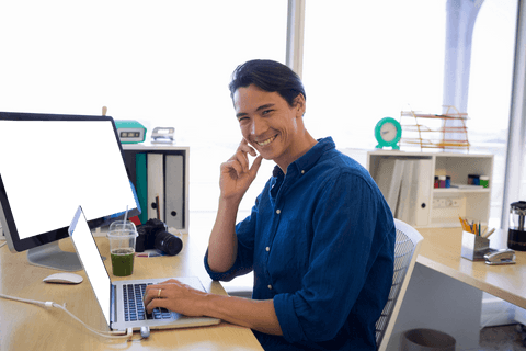 smiling businessman working on laptop with transparent desktop setup - Download Free Stock Videos Pikwizard.com