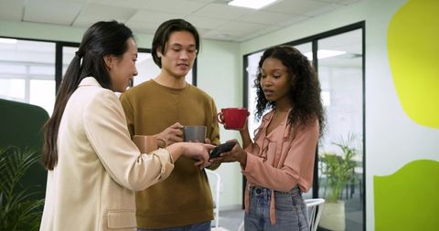 Team collaboration with coffee in modern office breakroom