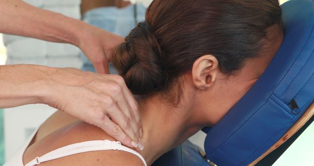 A Caucasian woman receives a neck massage from a therapist, with copy space. Highlighting the importance of wellness and self-care, the image captures a moment of relaxation and therapeutic touch.
