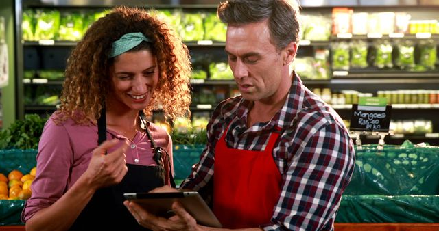 Grocery store workers discussing inventory using tablet - Download Free Stock Images Pikwizard.com