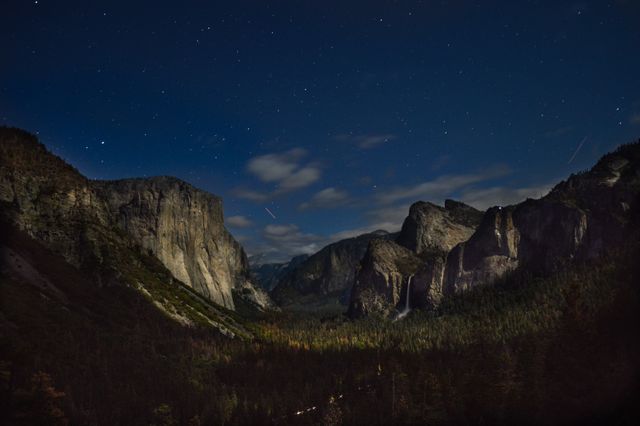 Night view of a starry sky above a mountain range in Yosemite National Park. Captures the tranquility and beauty of nature. Ideal for use in travel promotions, outdoor activity flyers, nature conservation campaigns, and astronomy-related content.