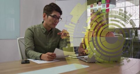 Collaborating colleagues pointing at documents, typing on laptop with sticky notes overlay