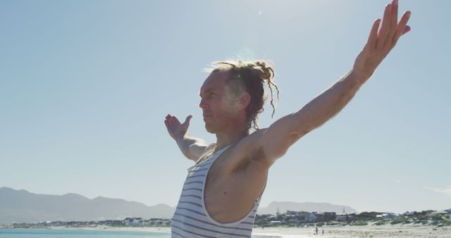 Man Stretching with Open Arms on Sunny Beach - Download Free Stock Images Pikwizard.com