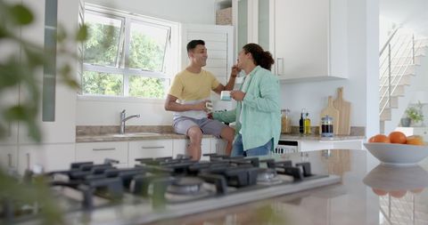Diverse Gay Couple Enjoying Morning Coffee in Bright Kitchen