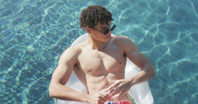 Young Man Relaxing on Inflatable in Sparkling Pool - Download Free Stock Images Pikwizard.com