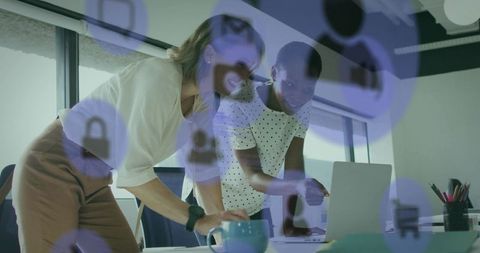 Collaborating on data security over laptop: business team pointing at screen in office