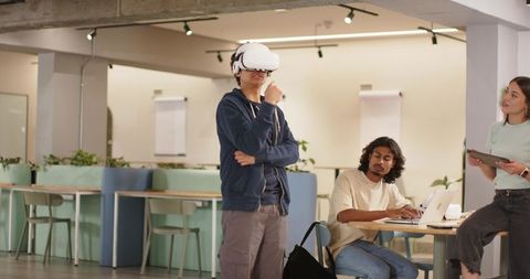 Young professionals testing VR headset during collaborative coworking workshop