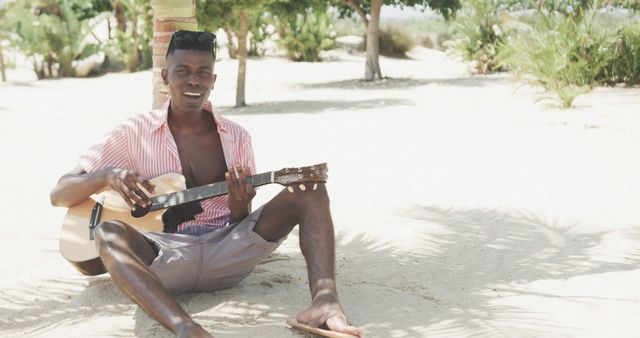 Young Man Playing Guitar Outdoors on Sunny Beach - Download Free Stock Images Pikwizard.com