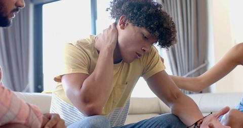 Friends comforting young man on sunlit couch showing support and empathy