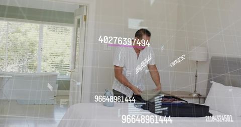 Asian man packing suitcase in modern sunlit bedroom with holographic data overlay for smart travel