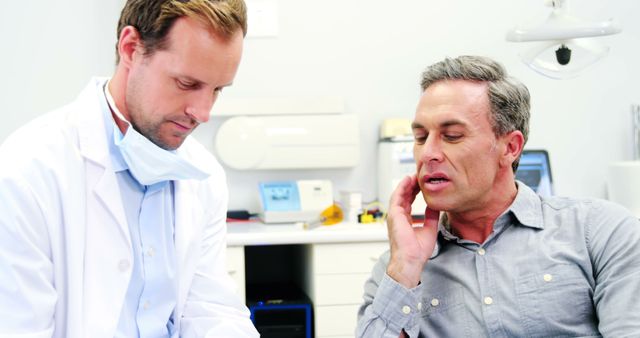 Middle-aged man consulting with doctor in medical office - Download Free Stock Images Pikwizard.com