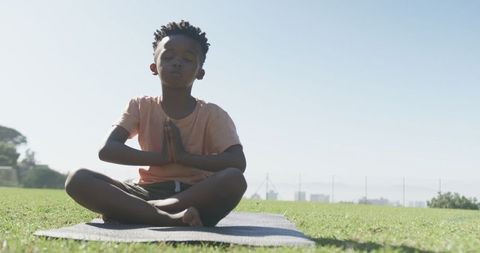 Young Boy Practicing Mindfulness Outdoors on Yoga Mat