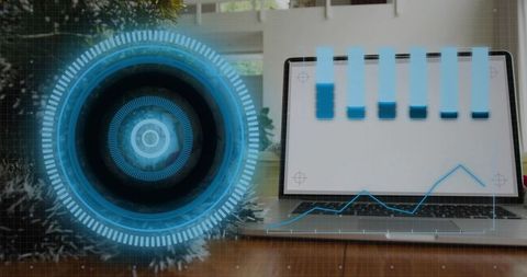 Displaying futuristic HUD overlay on laptop with blue analytics dashboard and data graphs